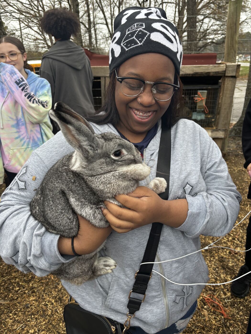 A smiling young grower holding a farm rabbit