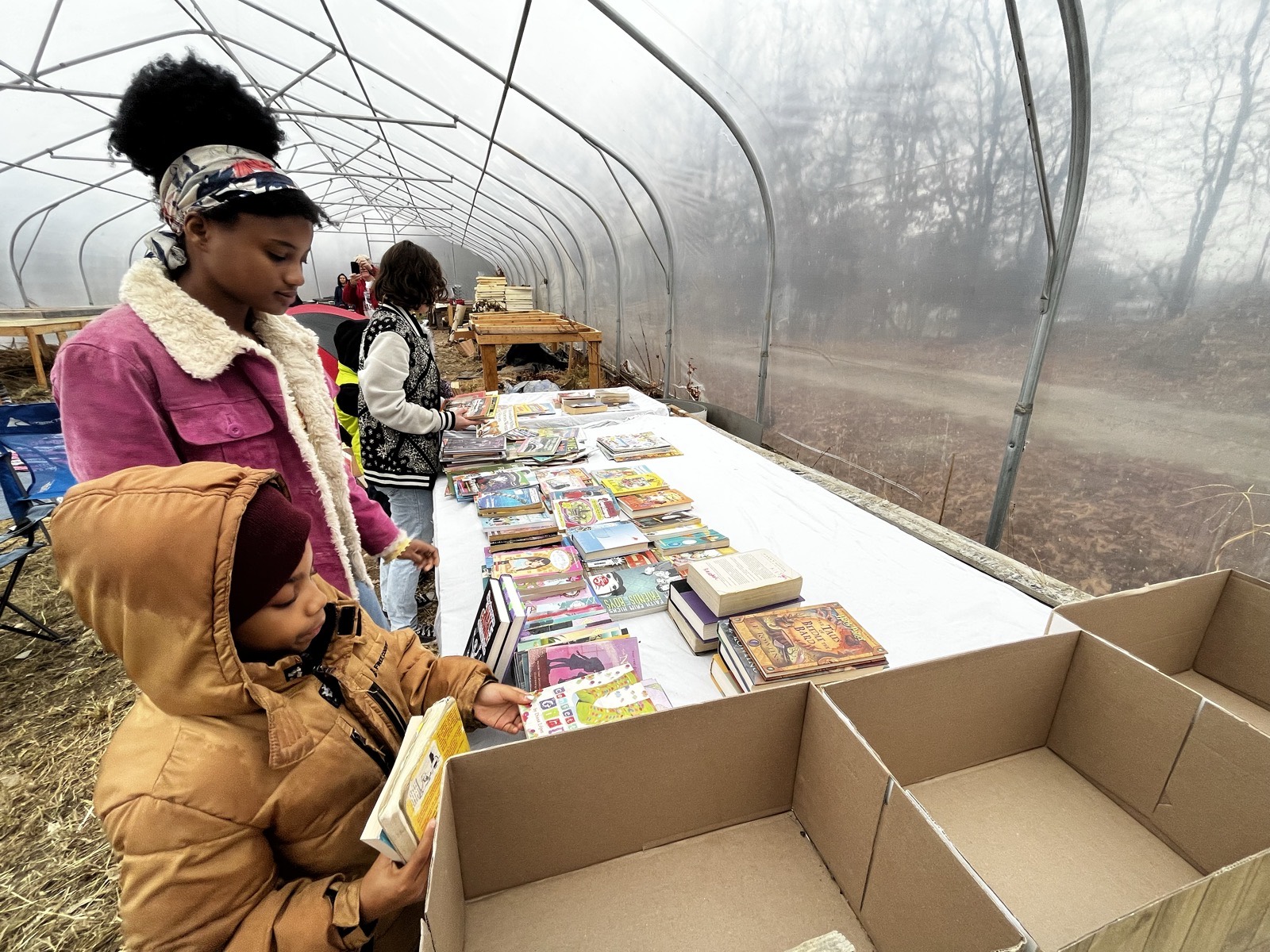 Little Lights browsing books at a literacy event in the farm greenhouse